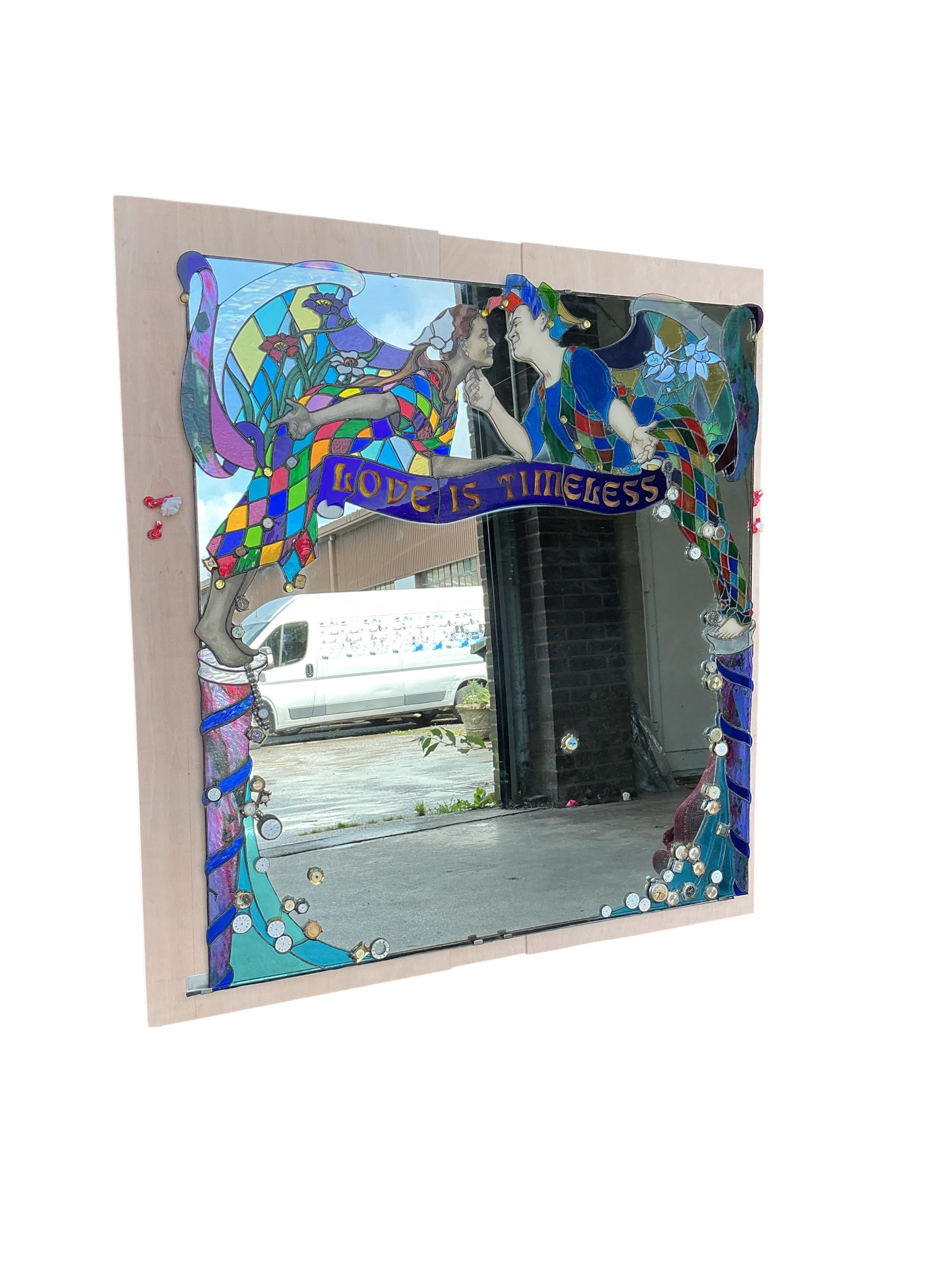 A Contemporary stained glass overmantel mirror “Love is Timeless” by Brighton artist Annelies Clark, the plate inset assorted wristwatch heads, width 128cm, height 138cm